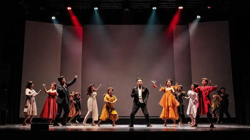 Escenario teatral con actores y iluminación vibrante