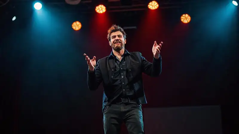 Actor expresivo con postura confiada y luces dramáticas
